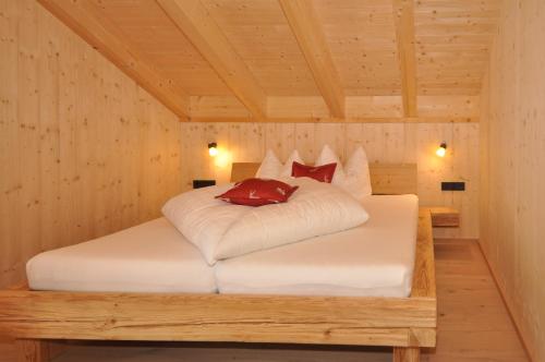 ein Schlafzimmer mit einem Bett in einem Holzzimmer in der Unterkunft Ferienhütten Lechtal Chalets in Elbigenalp