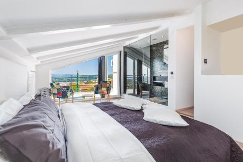 Un dormitorio con una cama grande con una ventana grande. en Villa Krasica, en Krasica