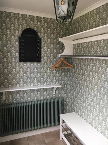 a room with green and white wallpaper and a radiator at Jaktlyckan, Tuna Gård in Tuna