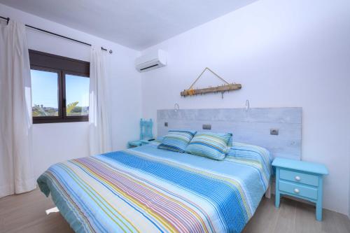 Dormitorio blanco con cama y mesa azul en Can Coques, en Sant Francesc Xavier