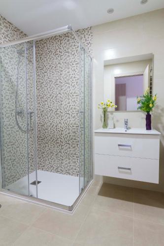 a bathroom with a shower with a sink and a mirror at Cabo Roig Terrazas de Campoamor 25 in Playas de Orihuela