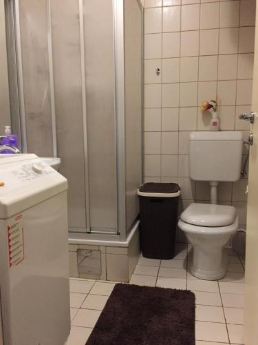 a bathroom with a shower and a toilet and a sink at Apartment Una - Self check in in Graz