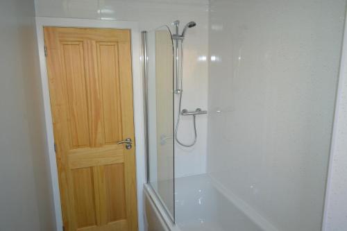 a bathroom with a shower with a glass door at Wick Apartment in Wick