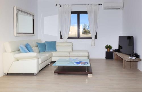 a living room with a white couch and a coffee table at Can Coques in Sant Francesc Xavier