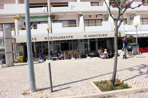 a building with people sitting outside of it at Cabanas Green Apartment & Loft. in Cabanas de Tavira
