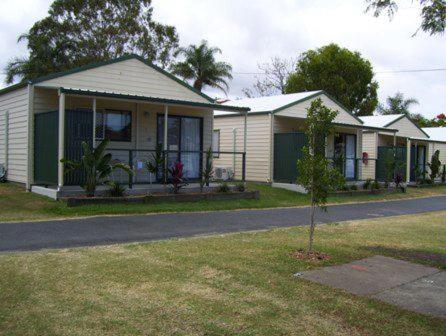 a house with a tree in front of it at Fraser Coast Top Tourist Park in Hervey Bay