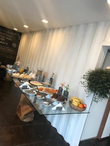a buffet of food on a glass table at Pousada Cafe Poesia in Campos do Jordão