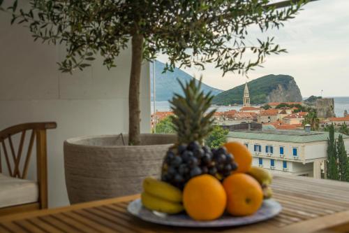 a plate of fruit on top of a table at Leona Residences Apartment in Budva