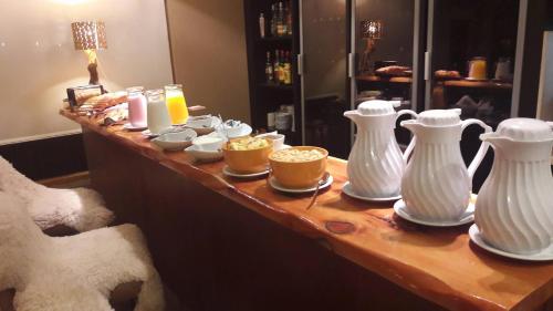 a table with white vases and cups on it at Galileo Boutique Hotel in San Carlos de Bariloche