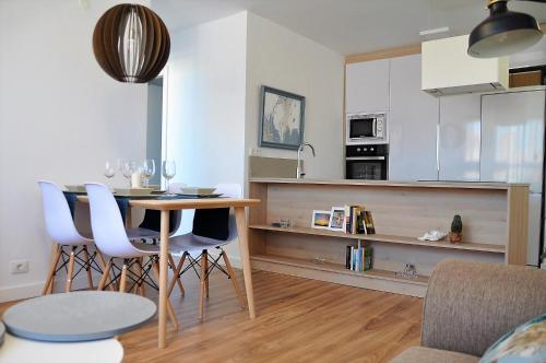 a kitchen with a table and chairs in a room at Apartamento en la Rambla con piscina in Santa Cruz de Tenerife