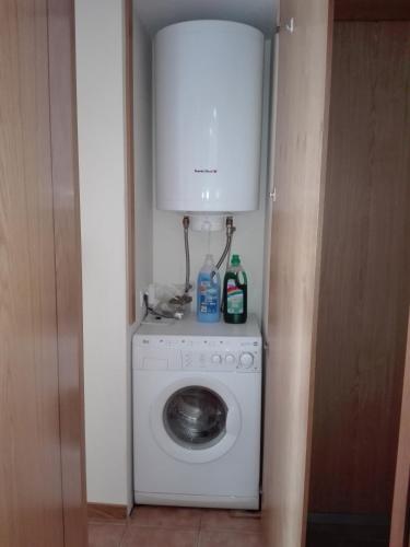 a laundry room with a washing machine and a cabinet at Apartamento Piscina Playa Cedeira in Cedeira