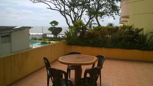 a table and chairs on a balcony with a view of the ocean at Departamento Torresol Tropical in Tonsupa