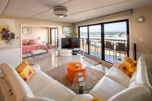 a living room with white furniture and a view of the ocean at Florence in South Padre Island