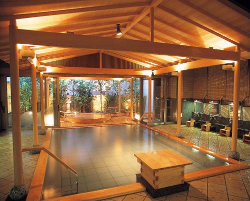 una piscina en medio de un pabellón con una mesa en Hatori, en Kaga