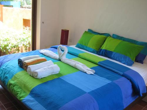 Una cama grande con toallas y cisnes. en Las Tortugas Apartment Unit C101, en Khao Tao