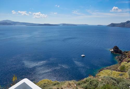 a boat in the middle of a large body of water at Helianthus Dream Homes in Oia