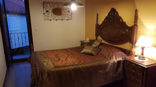 a bedroom with a large bed with a wooden headboard at Cantinho Ti Carlos in Pitões das Júnias