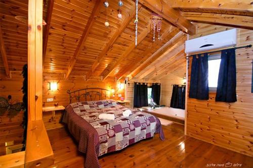 a bedroom with a bed in a wooden cabin at Hadas - Love in Wadi Keren