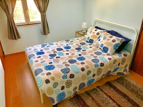 a bed with a comforter and pillows in a bedroom at POMBALINO! Lisbon Concept Apartments in Lisbon