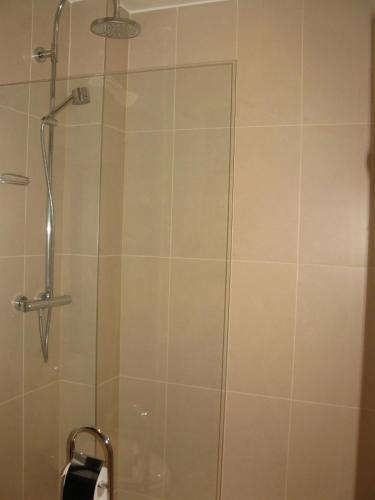 une douche dans une salle de bain avec une porte vitrée dans l'établissement Opera Apartment, à Paris