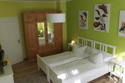 ein Schlafzimmer mit einem weißen Bett und grünen Wänden in der Unterkunft Ferienwohnung Hecht in Leipzig