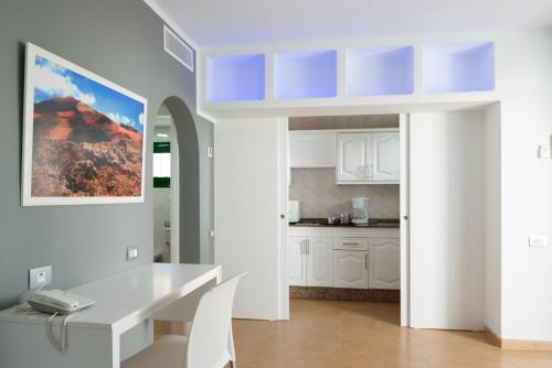 a kitchen with white cabinets and a white table at Hyde Park Lane in Puerto del Carmen