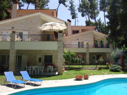 una casa con una piscina di fronte di Mira Forest Residences a Sani Beach