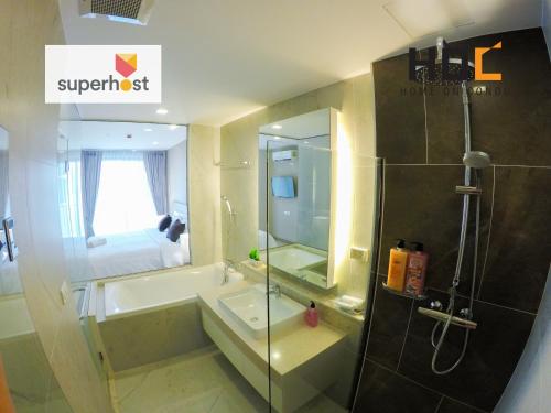 Un baño con ducha, bañera y lavabo. en HOC5 The Astra Condo Chiang Mai Night Bazaar, en Chiang Mai