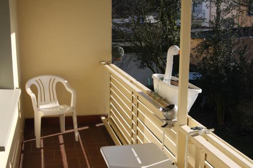 Hotel garni Zum Drosten في Balve: كرسي أبيض جالس على شرفة مع مرحاض