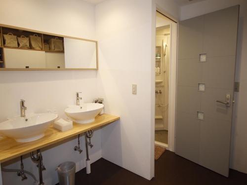 a bathroom with two sinks and a mirror at Minato Hutte in Kobe