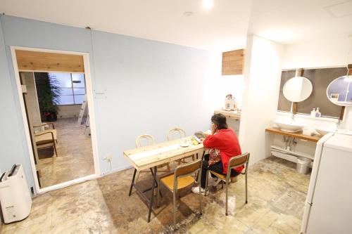 a woman sitting at a table in a kitchen at Minato Hutte in Kobe