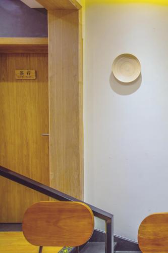 a room with a door and a table and chairs at Han Xuan Boutique Hostel in Hangzhou