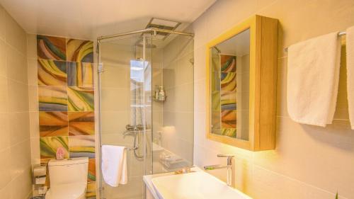 a bathroom with a shower and a toilet and a sink at Han Xuan Boutique Hostel in Hangzhou