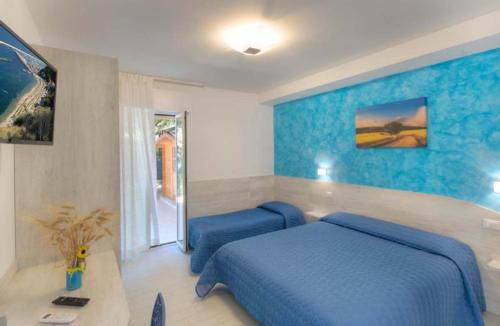 a bedroom with a blue bed and a table at Affittacamere I Principi del Conero in Numana