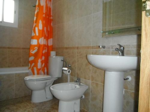 オリフエラ・コスタにあるApartments La Cinuelica LC162のバスルーム(オレンジ色のシャワーカーテン、トイレ、シンク付)