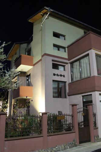 a large white building with a fence in front of it at Guest House Dara in Tsarevo