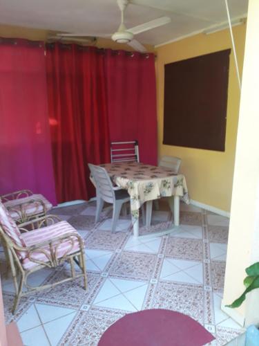 a room with a table and chairs and a screen at Fleurvilla in Pereybere