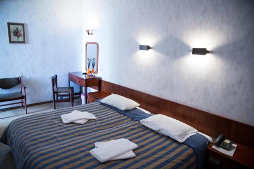 ein Hotelzimmer mit einem Bett mit Handtüchern darauf in der Unterkunft Violetta in Kamena Vourla