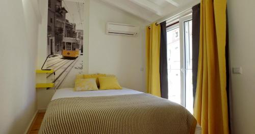 ein Schlafzimmer mit einem Bett und ein Fenster mit einem Zug in der Unterkunft Alfama 44 in Lissabon