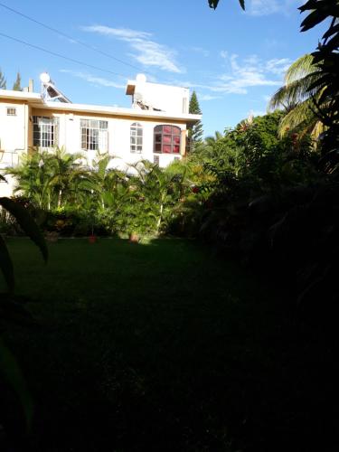 a white house with a lawn in front of it at Fleurvilla in Pereybere