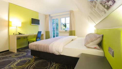 a hotel room with a large bed and a desk at Hotel Landgasthof Bären in Trossingen