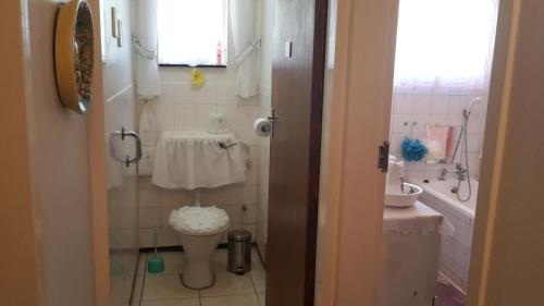 a small bathroom with a toilet and a sink at Heila's in house Family room-Homestay! in Bloemfontein