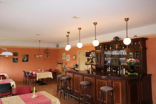 a restaurant with a bar with tables and chairs at Pension Goerke in Kritzkow