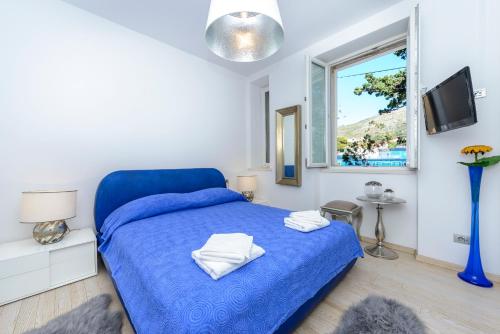 a bedroom with a blue bed and a window at Holiday Home Villa Rosemary in Dubrovnik