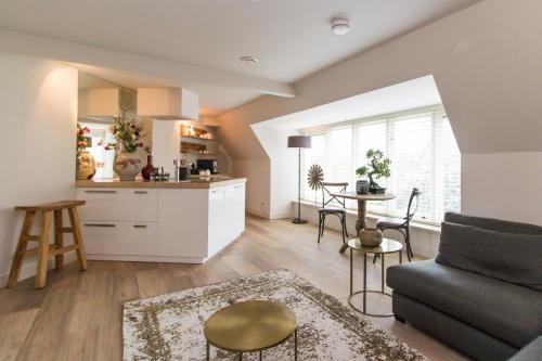 a kitchen and living room with a couch and a table at Short stay Midden Drenthe in Beilen