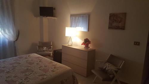 a bedroom with a bed and a lamp and a chair at Hotel President in Chianciano Terme