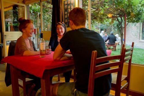 a group of people sitting at a table in a restaurant at La Tosca Hostel in Puerto Madryn