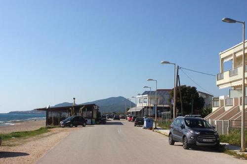 a street with cars parked on the side of a beach at Apartment Elisabeth in Kanali