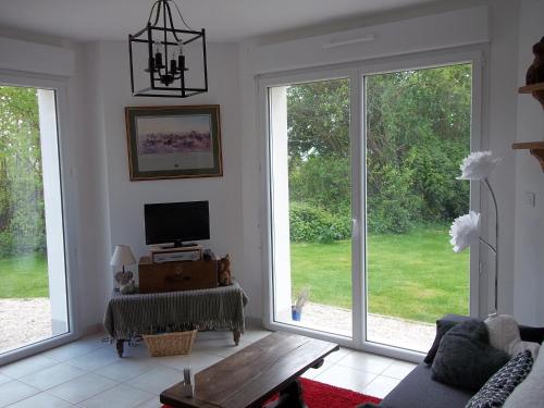 a living room with large windows and a tv at Fairbanks in Hardecourt-aux-Bois
