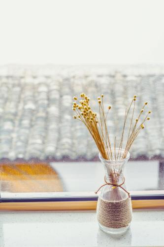 a vase with flowers sitting on a window sill at Han Xuan Boutique Hostel in Hangzhou